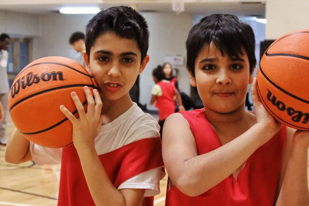 Two boys playing basketball at Kerr Street Mission in Oakville, Ontario, part of children's programs